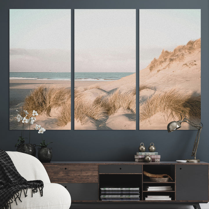 Soft pastel-toned beach scene with sand dunes, windswept grasses, and a calm ocean horizon, creating a serene coastal atmosphere.
