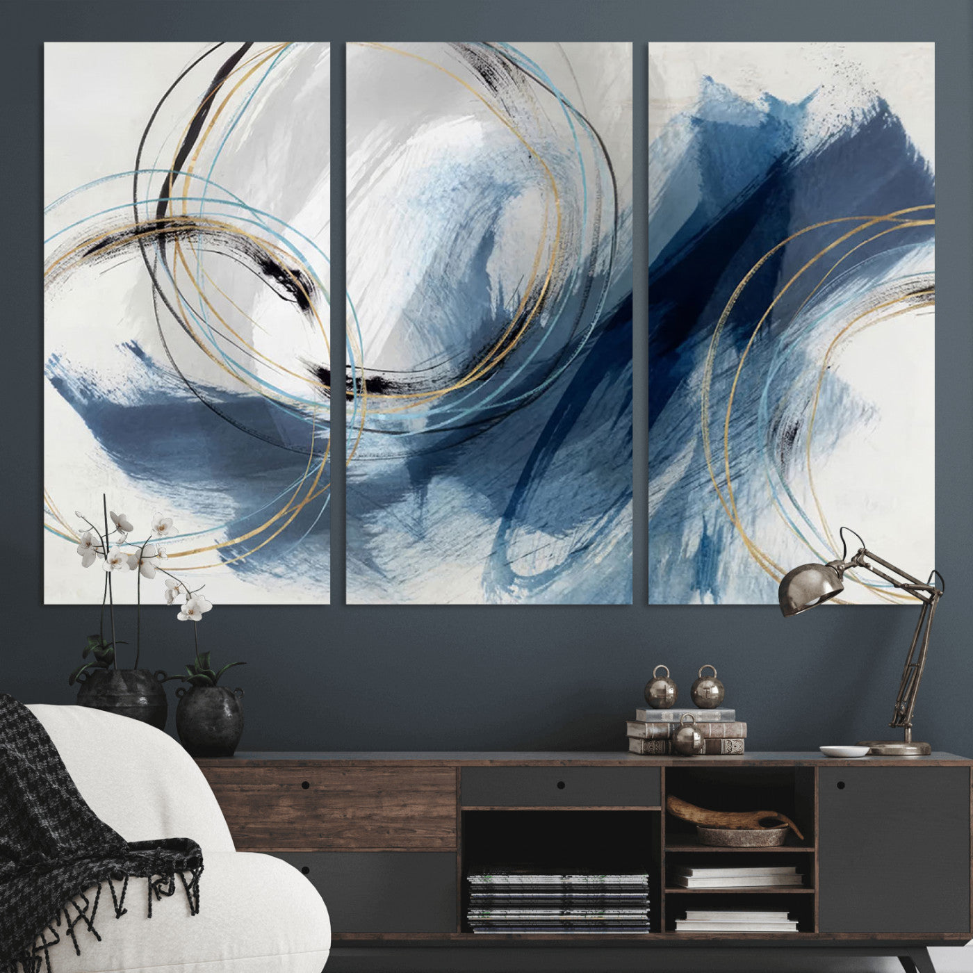 Abstract wall art featuring dynamic brush strokes in shades of blue and gray, overlaid with delicate circular line patterns in gold, black, and light blue on a white background.
