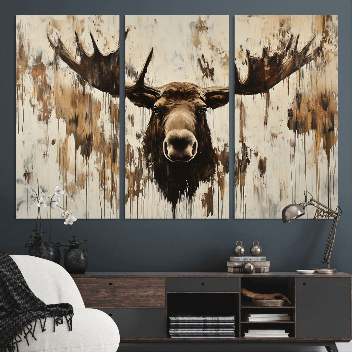 Expressive painting of a moose head with wide antlers in dark brown and beige tones, featuring paint drips and splatters on a light textured background, creating a striking rustic wall art canvas.