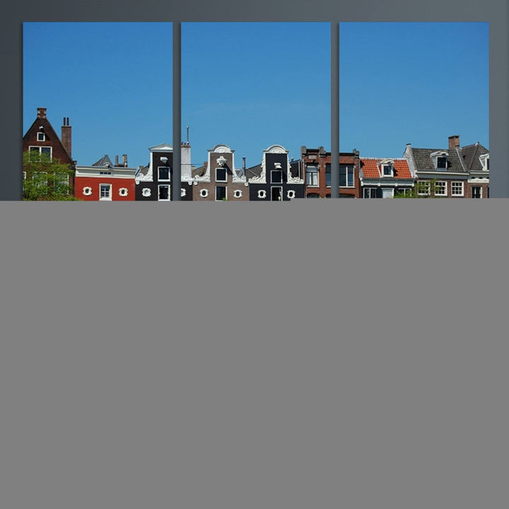 The Amsterdam City Wall Art Canvas Print showcases colorful traditional canal houses and boats set against a clear blue sky.