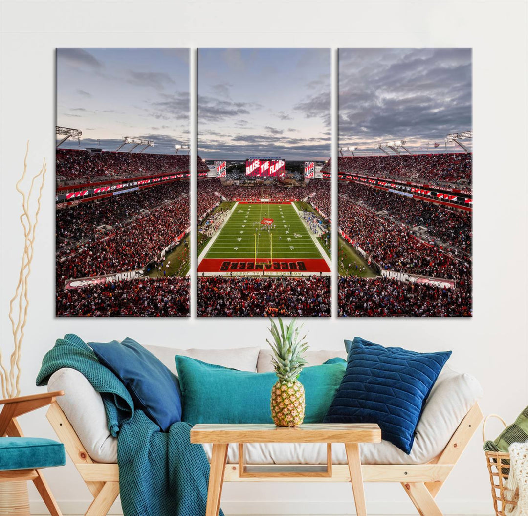 The wall art captures a stunning scene of Raymond James Stadium bathed in the warm hues of sunset. The sky, filled with clouds, provides a dramatic contrast to the vibrant lighting on the field, encapsulating the dynamic energy of a football game.