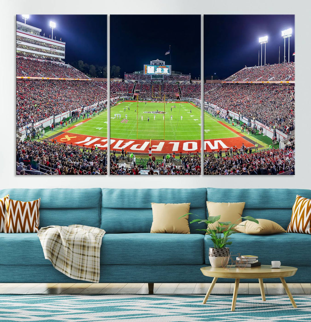 A NC State Wolfpack Football Team print of Carter-Finley Stadium at night features WOLFPACK illuminated brightly in the end zone grass.