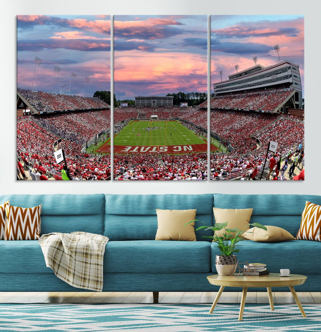 The wall art captures an NC State Wolfpack game under a vibrant sunset on triple canvas.