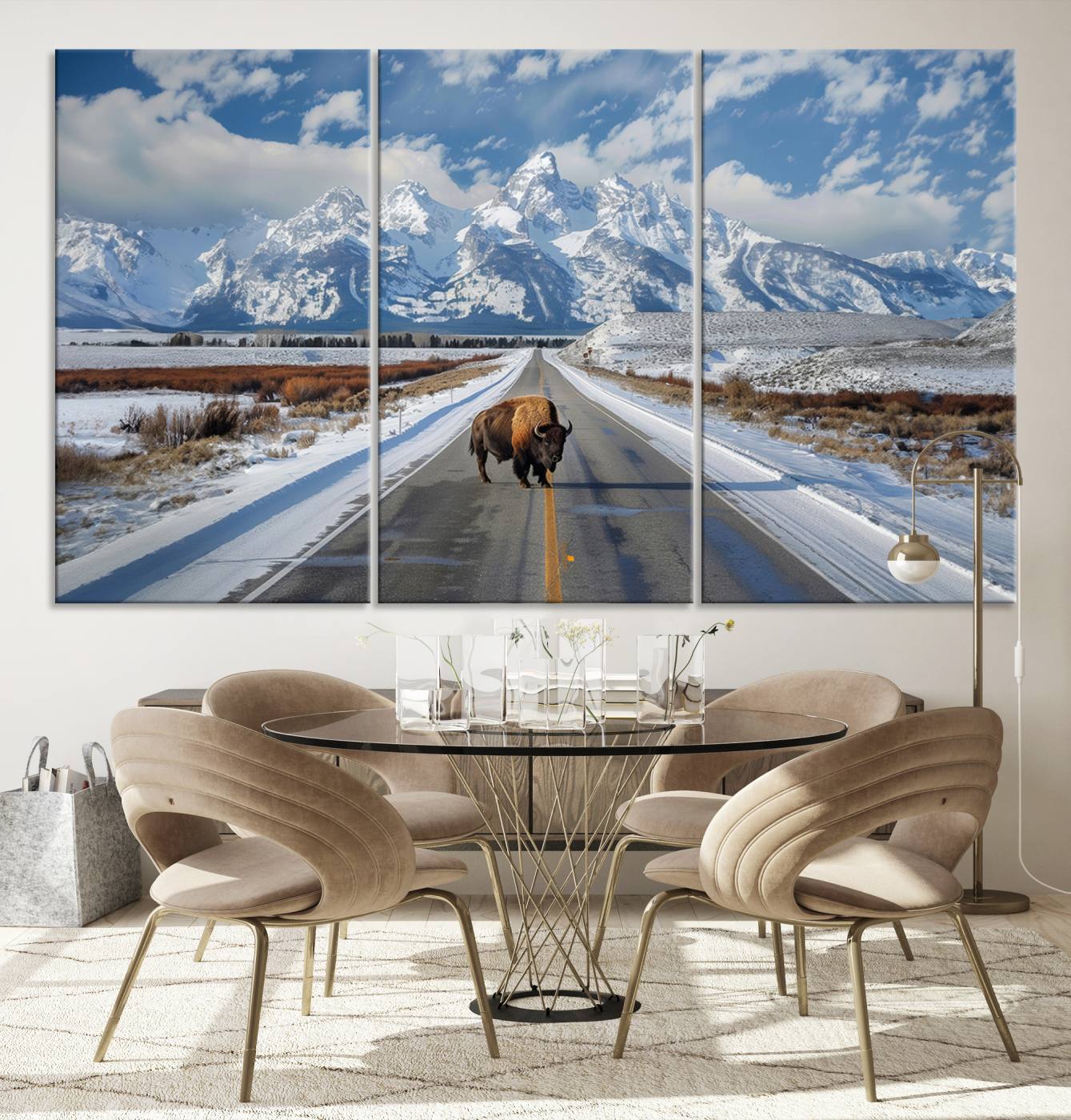 A powerful bison stands on a snow-dusted road beneath the towering peaks of the Grand Tetons, capturing the untamed beauty of America's winter wilderness.