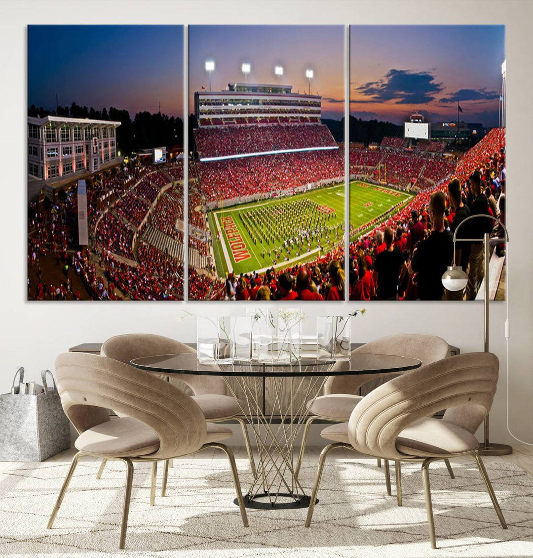 A print of a bustling Carter-Finley Stadium at dusk, featuring fans and a band, captures the essence of NC State Wolfpack football.