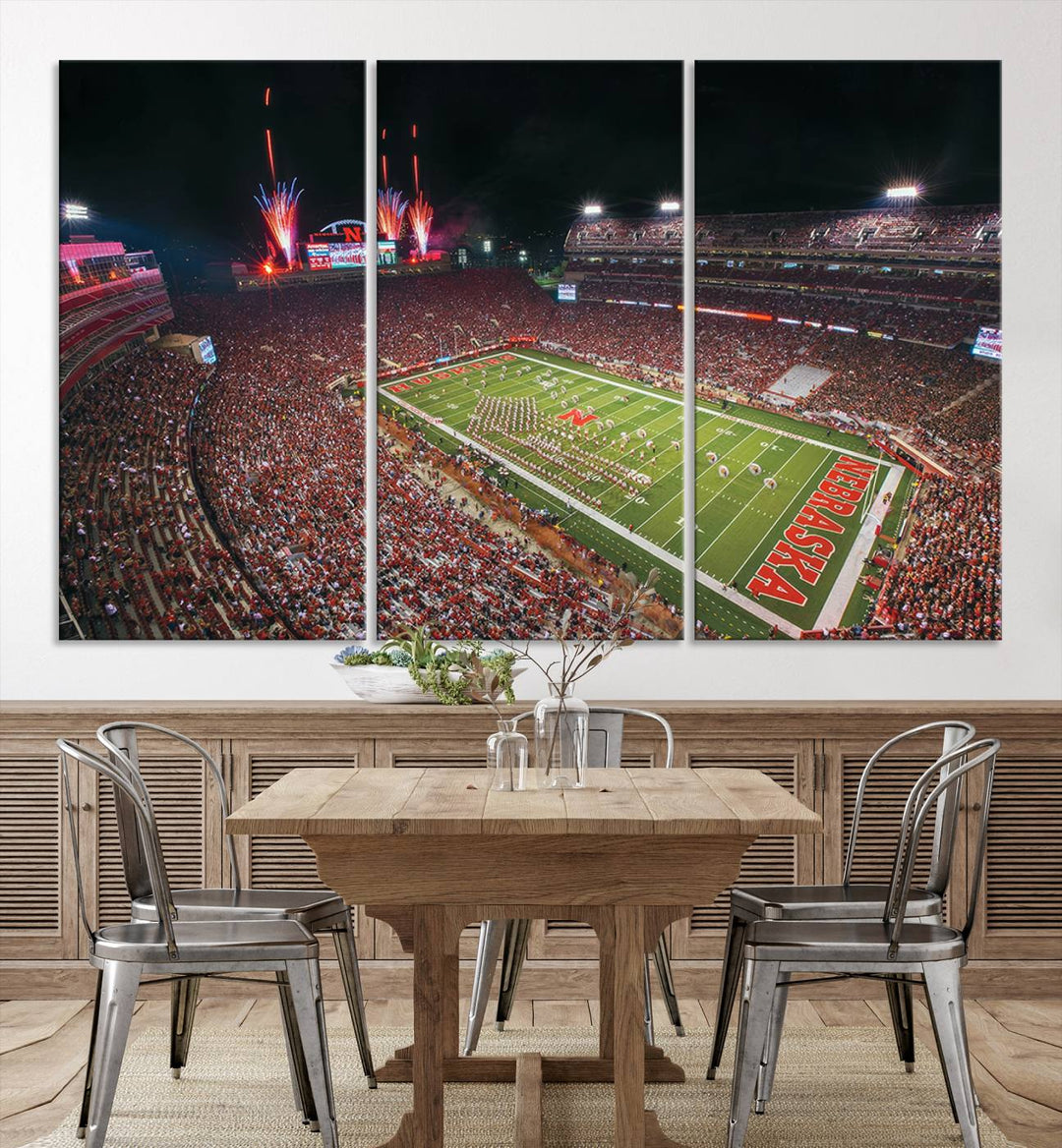 The University of Nebraska Cornhuskers Football Team Print, featuring Lincoln Memorial Stadium in a vibrant triptych canvas with fireworks above and a gallery-quality finish, is elegantly displayed.