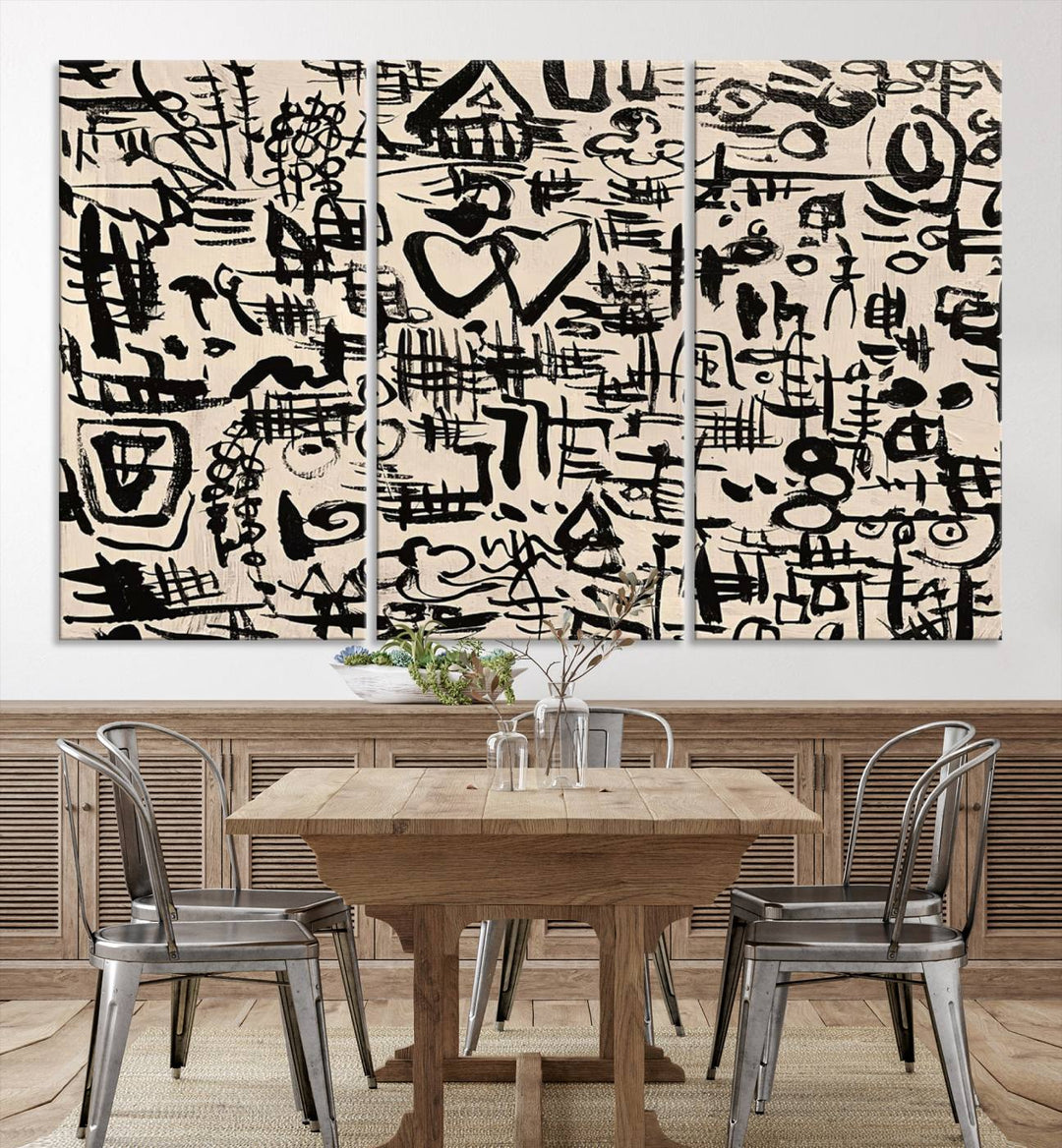 The Abstract Love and Chaos canvas is a museum-quality print featuring black symbols on a beige background, adorned with a heart and scribble design. It is framed to enhance its artistic appeal.