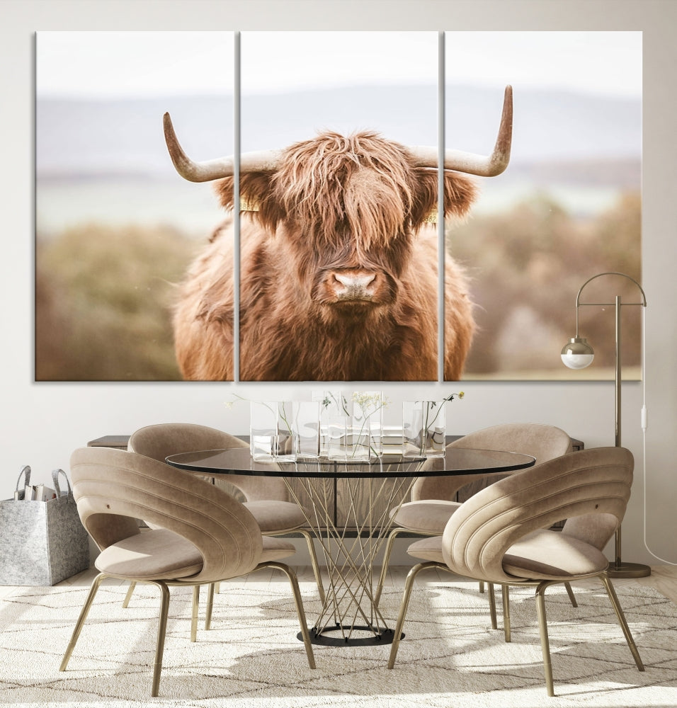 The Scottish Highland Cow Canvas Wall Art features a serene depiction of a Highland cow in natural pastel tones, adding an elegant touch to the farmhouse-inspired decor.