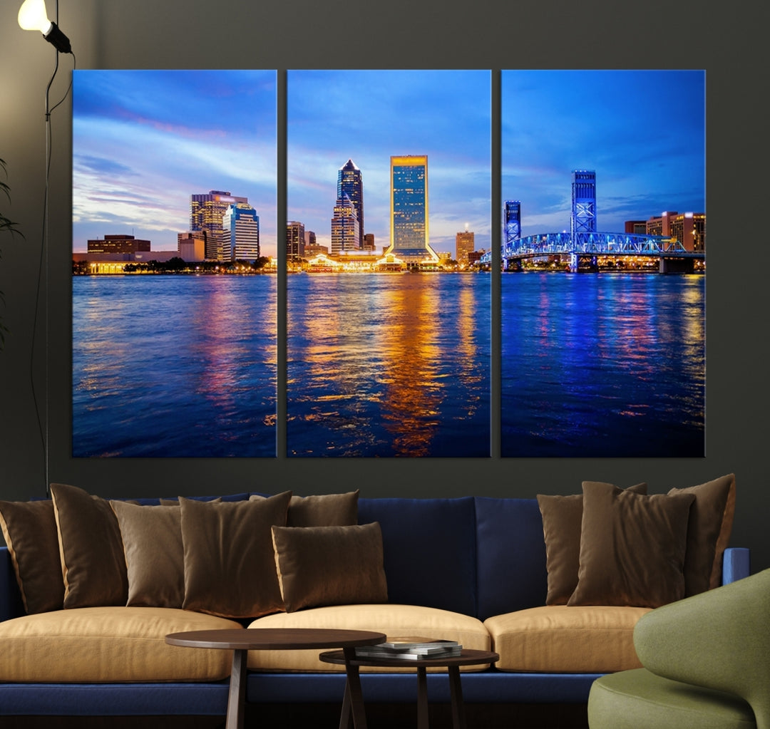 A cozy living room features the Jacksonville Wall Art Canvas Print, a large triptych crafted on museum-quality canvas that beautifully depicts the Jacksonville city skyline at sunset.