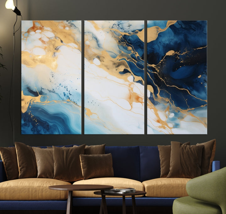 A modern living room featuring museum-quality Blue Gold Abstract Wall Art Print Contemporary art in a triptych arrangement.