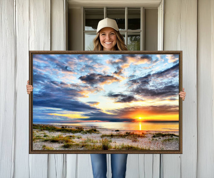 The Sunset On The Ocean canvas wall art features a beautiful beach sunset with grass and clouds.