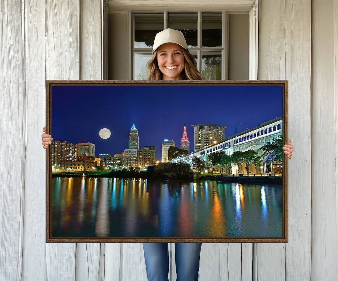 Cleveland City Lights Night Skyline Wall Art canvas showcases a moonlit cityscape reflected on water.