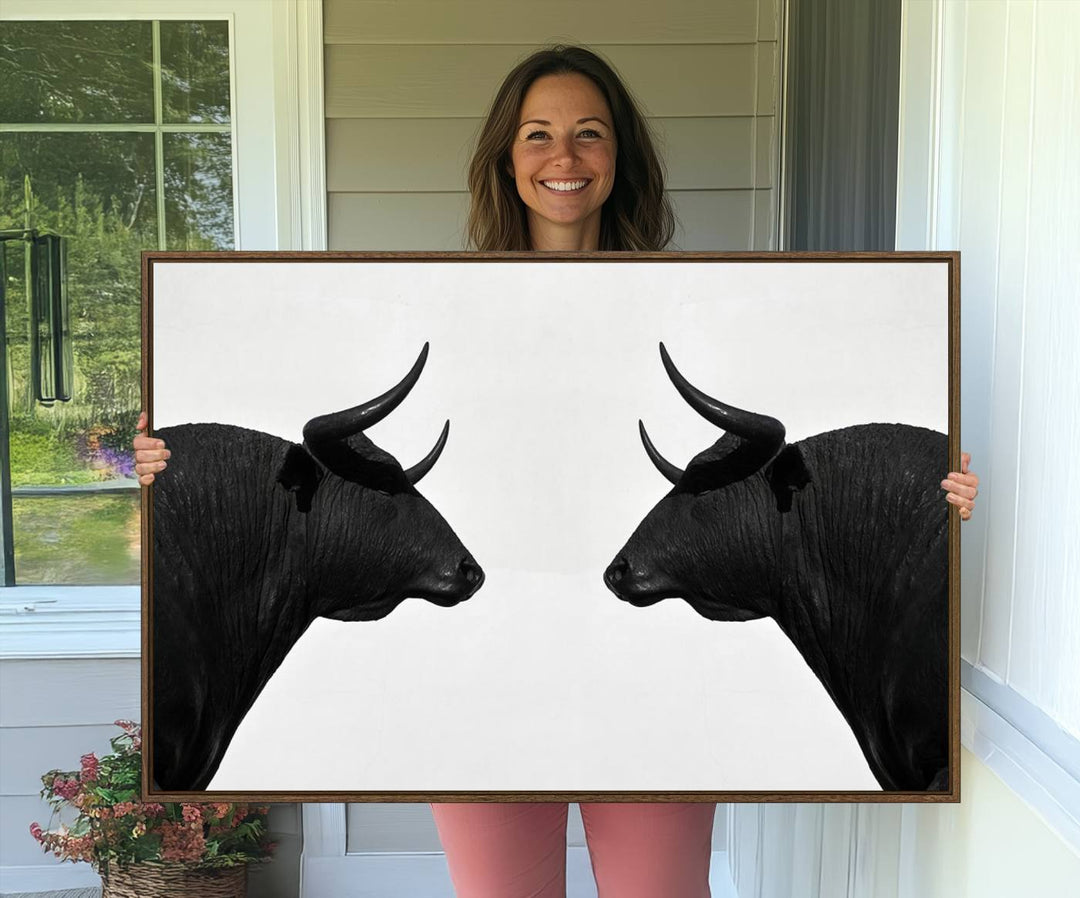 A framed canvas print featuring two black bull silhouettes, perfect for modern rustic decor.