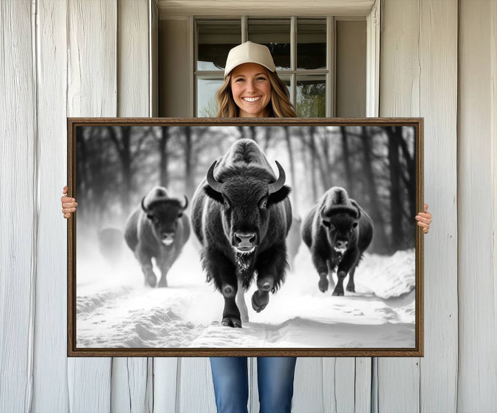 The Buffalo Wall Art Canvas Print of bison running through snow adorns the wall.