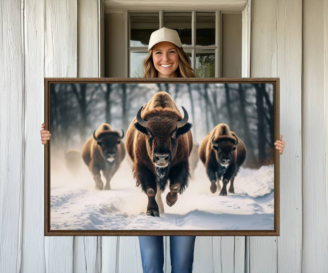 Wall art titled Cow Bighorn shows three bison running through snow in a forest.