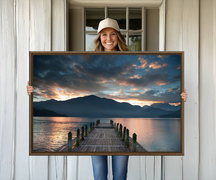 The Mountain Lake Wood Pier Canvas Wall Art depicts a serene lake and mountains, enhancing the beauty of any space.