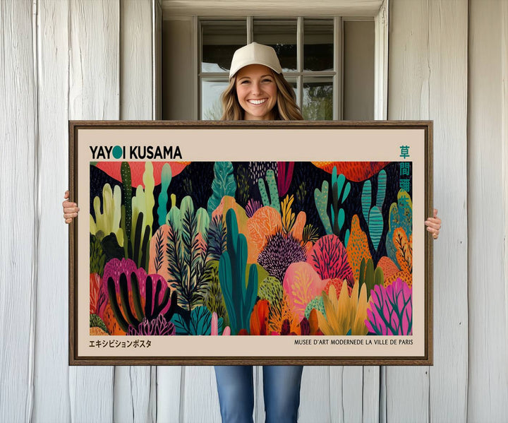 The vibrant canvas print of wall art features abstract plants, with the elegant text "Yayoi Kusama Wall Art Canvas Print" displayed on the colorful frame.