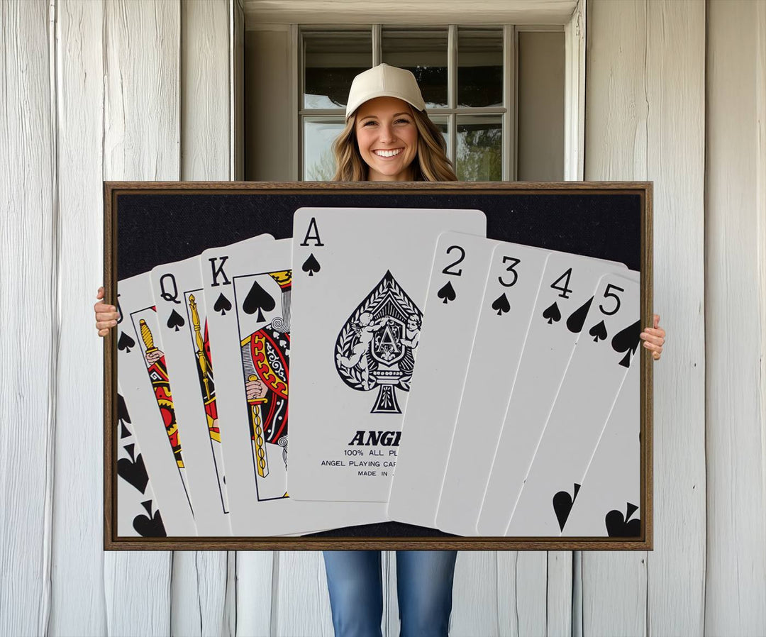 The Poker Wall Art - Playing Cards Canvas Wall Art Print features an Ace of Spades and Royal Flush design. This piece adds a classic charm to any space with its subtle emphasis on the Ace of Spades, making it perfect for game room decor.