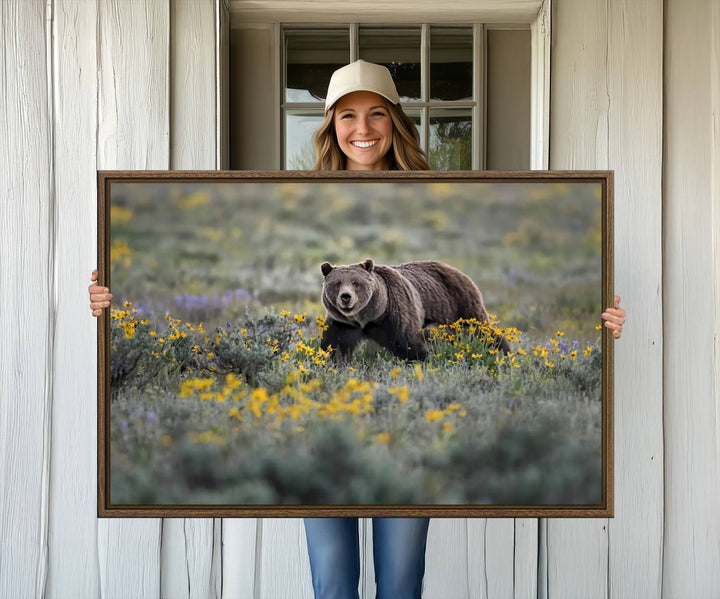 The "Grizzly 399 in Wild Flowers Wall Art Canvas Print" features a grizzly bear strolling through a field of yellow and purple flowers, beautifully showcased as a triptych. This handcrafted piece, proudly made in the USA, adds charm and sophistication to your space.