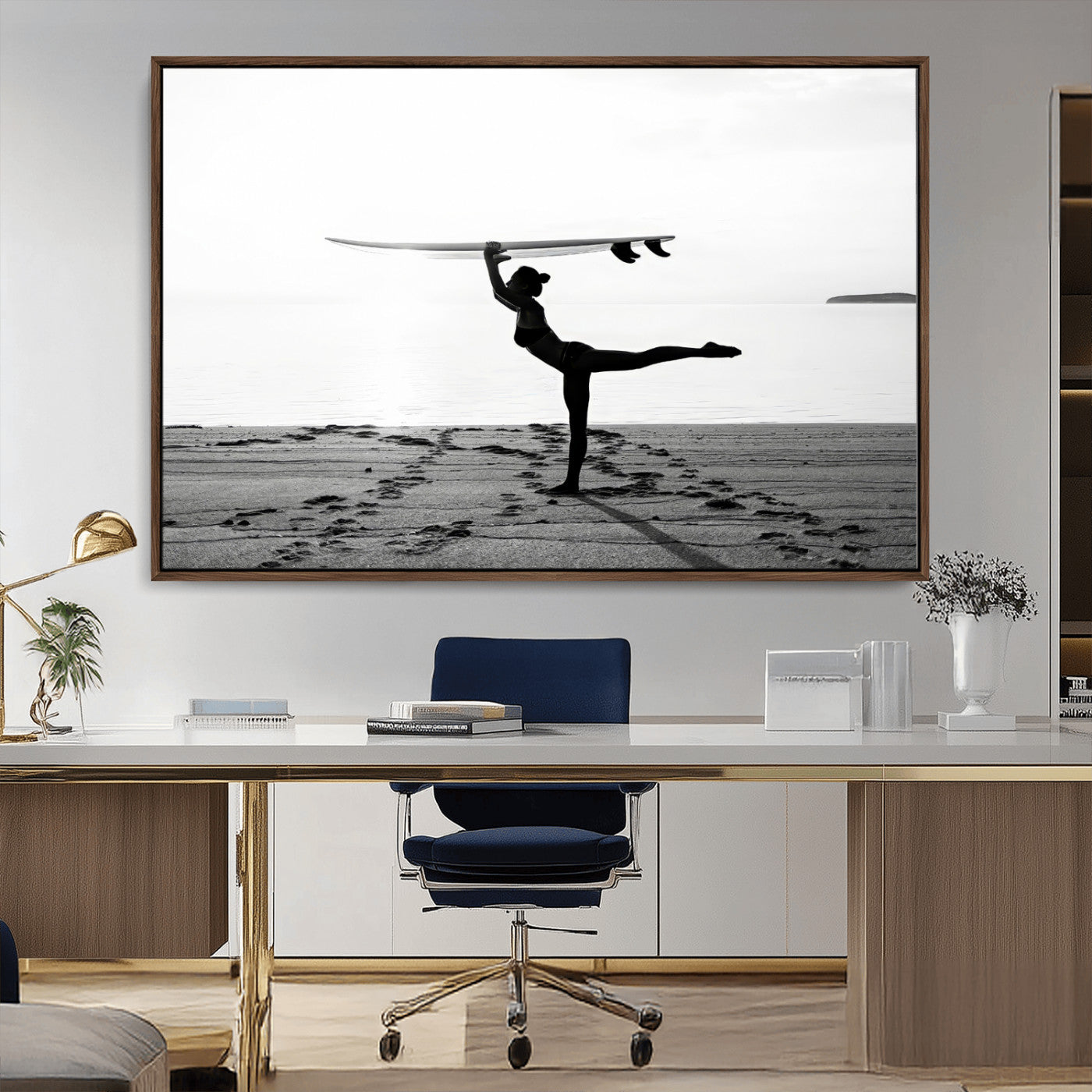 A woman balances a surfboard on her head while striking a yoga pose on the beach, silhouetted against a calm ocean horizon.