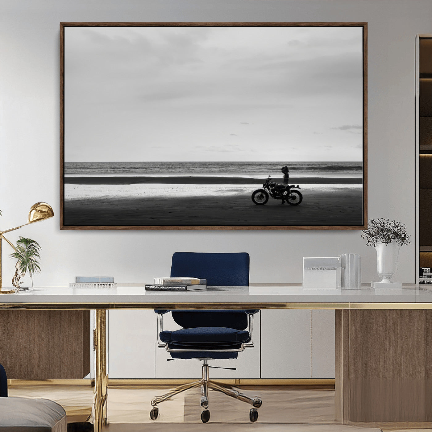 A motorcyclist on a vast beach, gazing at the ocean, capturing a moody and tranquil coastal adventure in black and white.