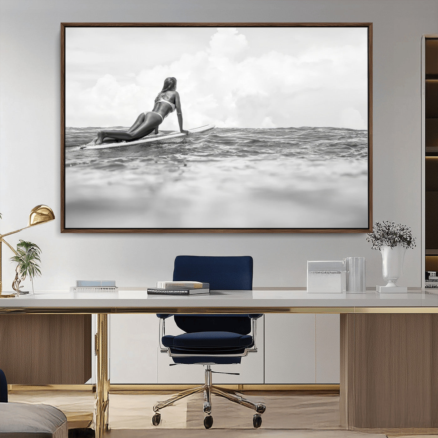 A black and white ocean scene featuring a surfer girl waiting on her board, gazing at the horizon, capturing a tranquil and adventurous coastal moment.
