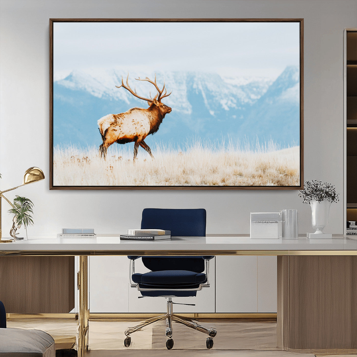 Majestic elk standing on dry grassland with snowy mountains in the background, ideal for rustic or lodge-inspired wall decor.