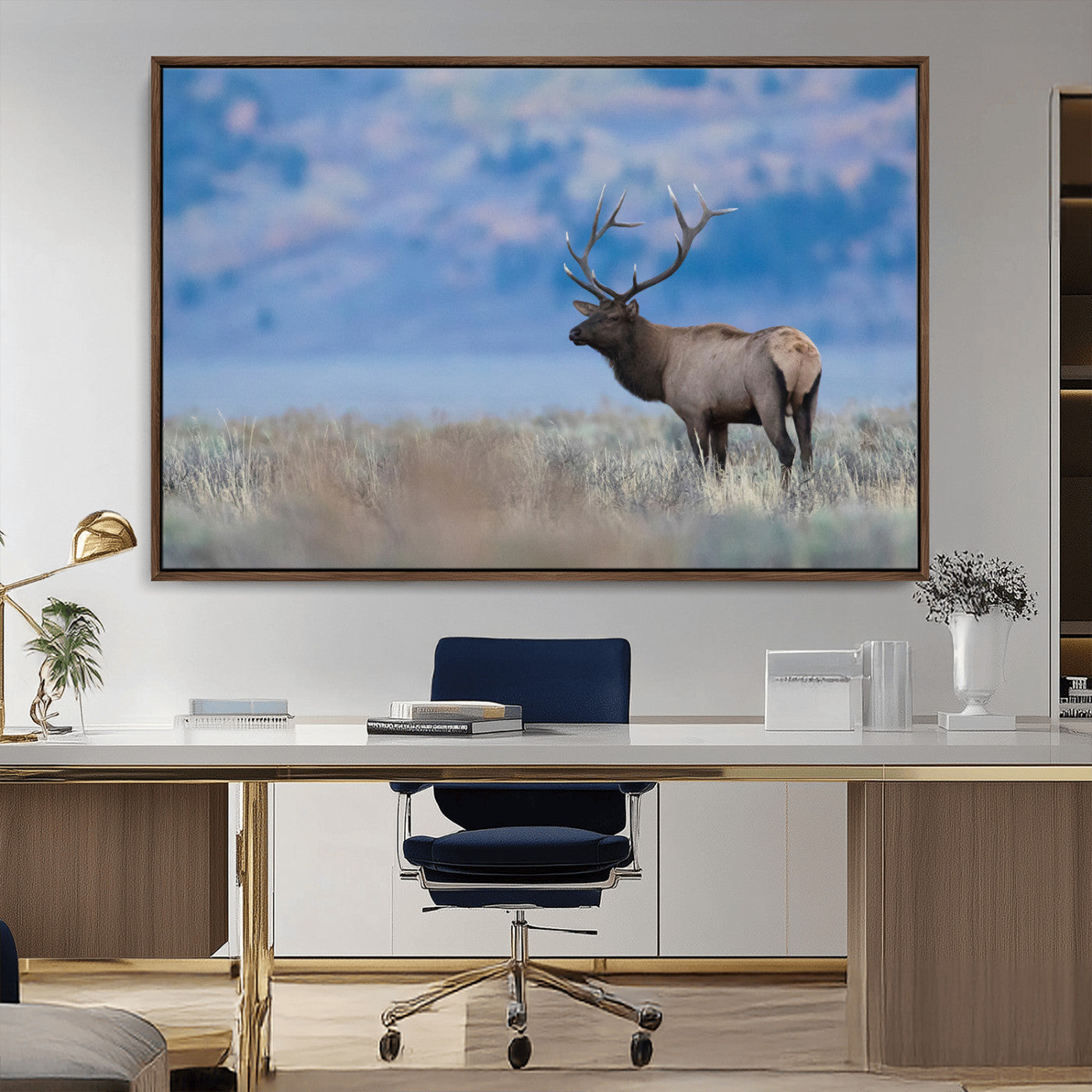 Elk with large antlers standing in open field, mountains blurred in background, perfect for rustic cabin or lodge-style decor.