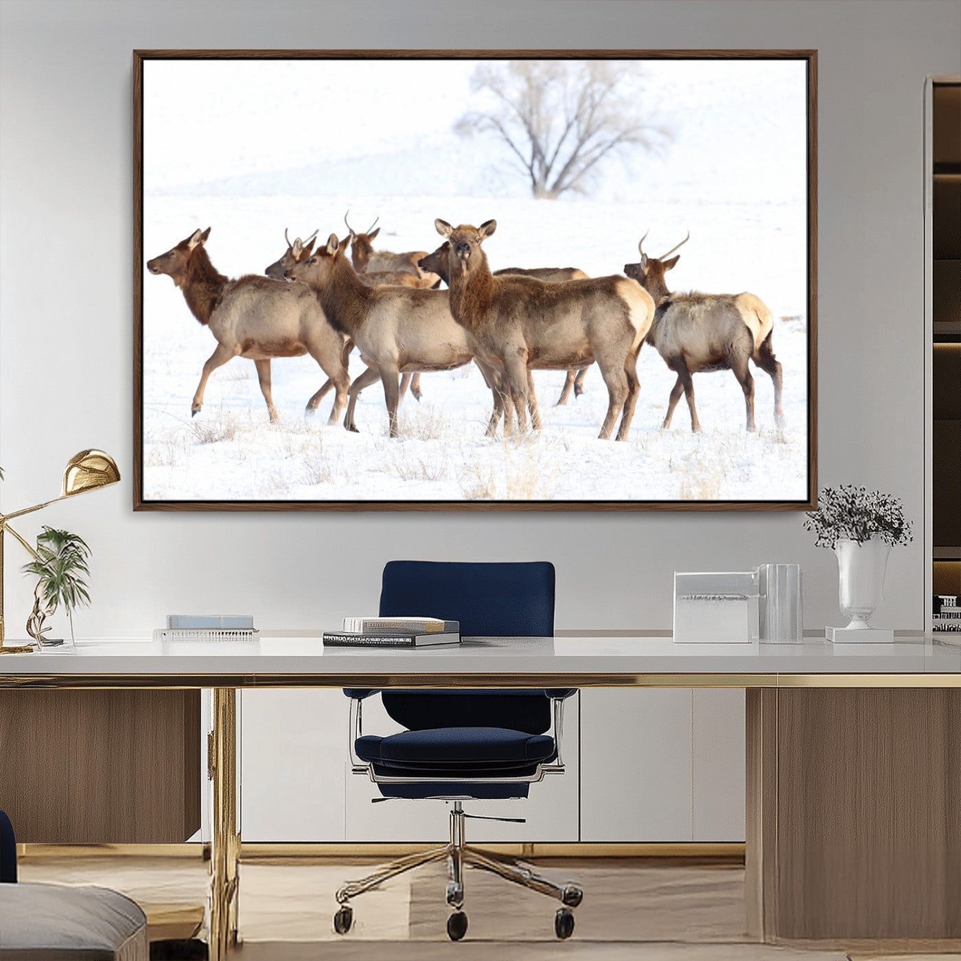 A group of elk standing on snowy terrain with a tree in the background, perfect for rustic or lodge-style winter wall decor.