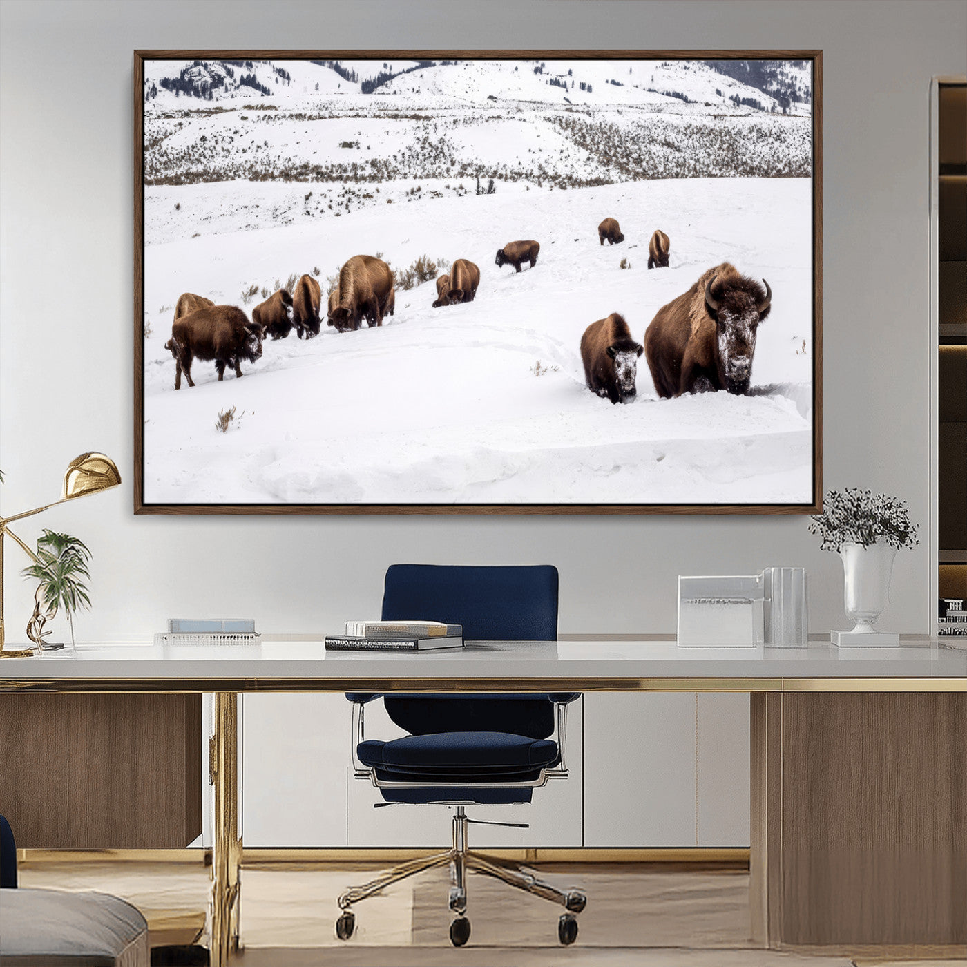 A herd of bison walking through deep snow in a mountain valley, perfect for rustic, cabin or western-themed wall decor.