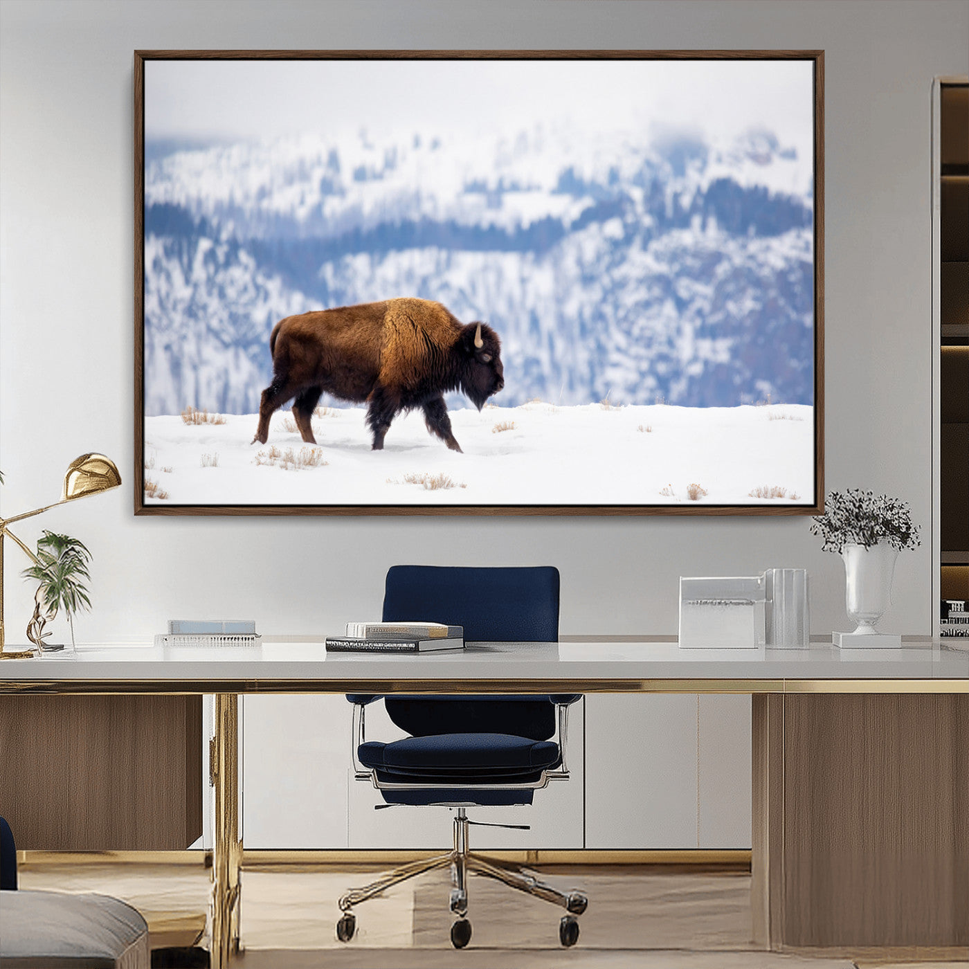 A lone bison walks across snowy ground with blue-toned mountain range behind, ideal for rustic or western farmhouse interiors.