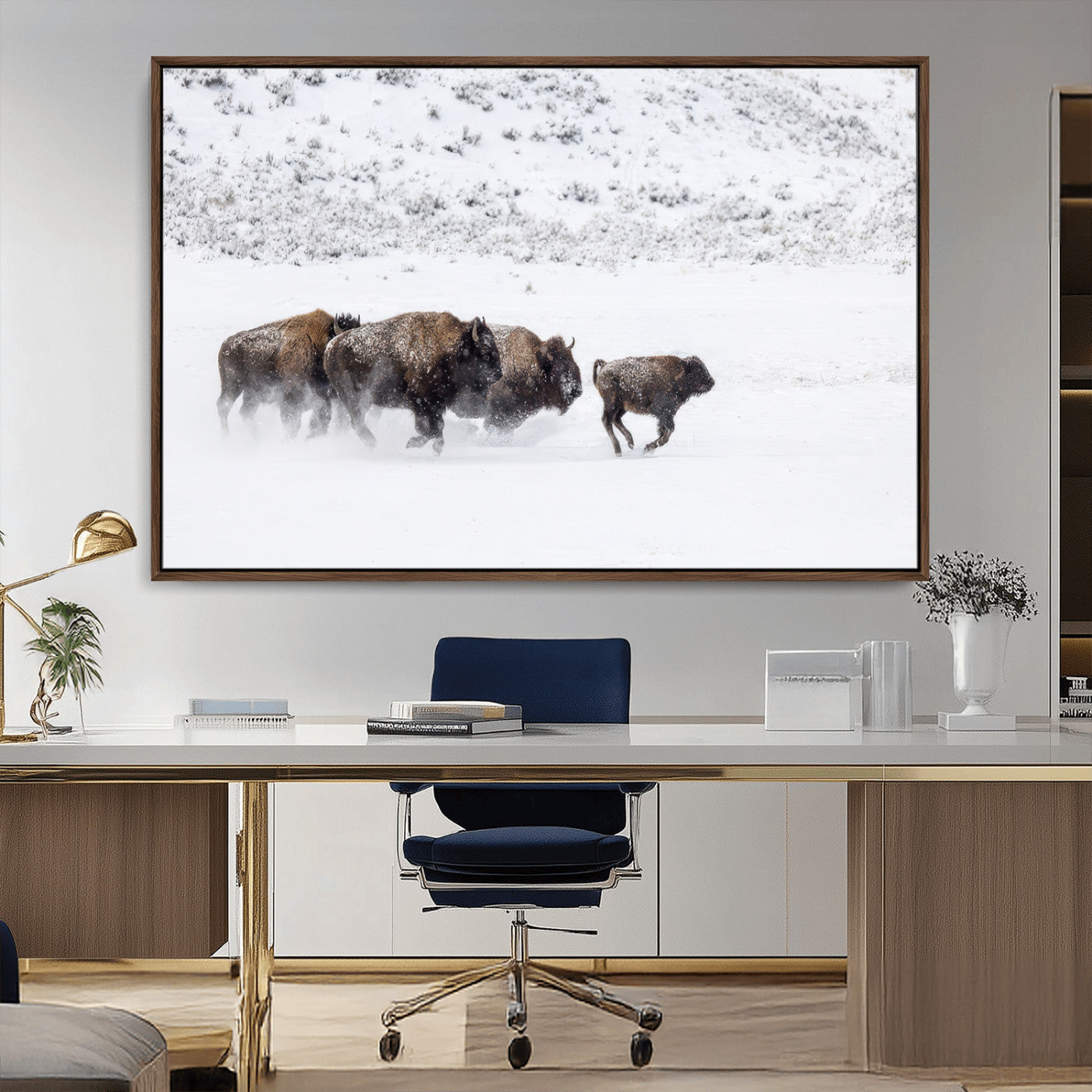 Bison herd running through a snowy open field with mountain backdrop, perfect for rustic or western-themed wall decoration.