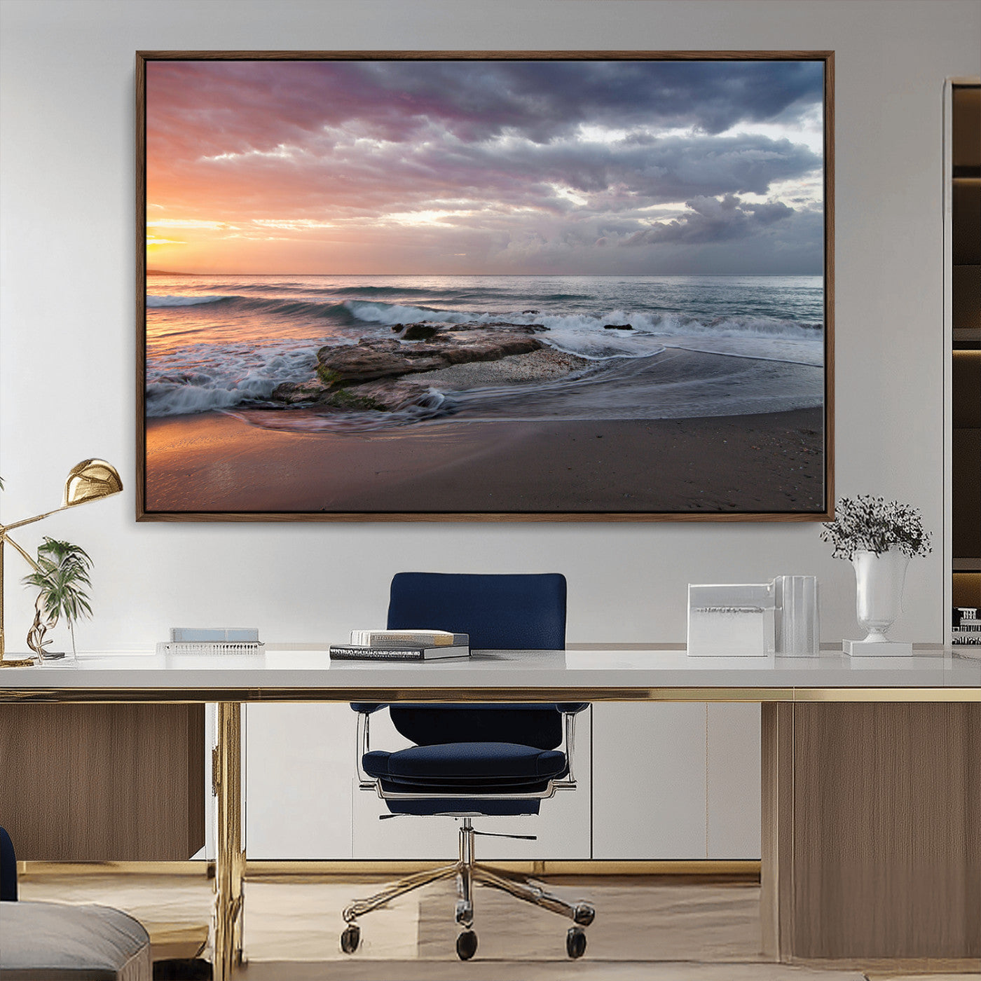 Dramatic sunset over a rocky shoreline with ocean waves gently reaching the sandy beach, creating a serene and coastal atmosphere.