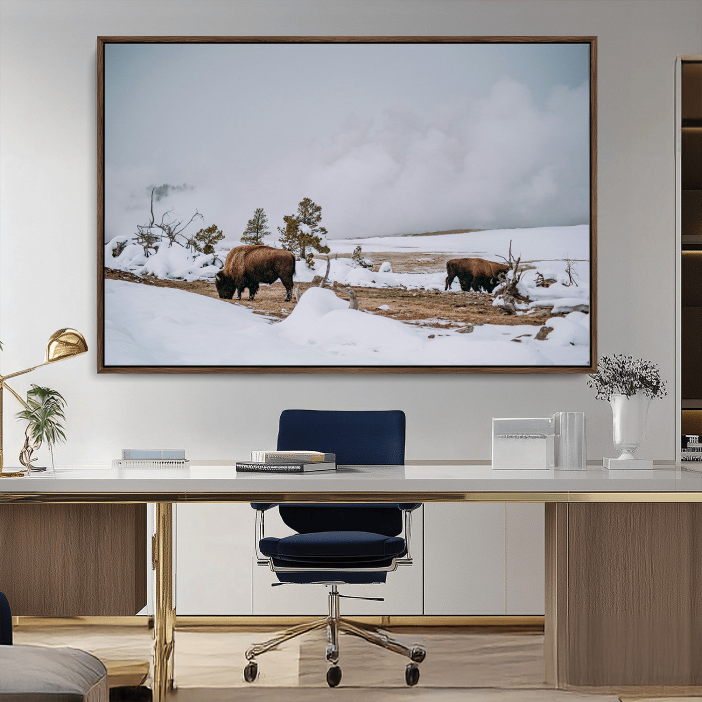 Two bison grazing in a snowy open landscape with misty hills in the background, creating a peaceful and rustic winter scene.
