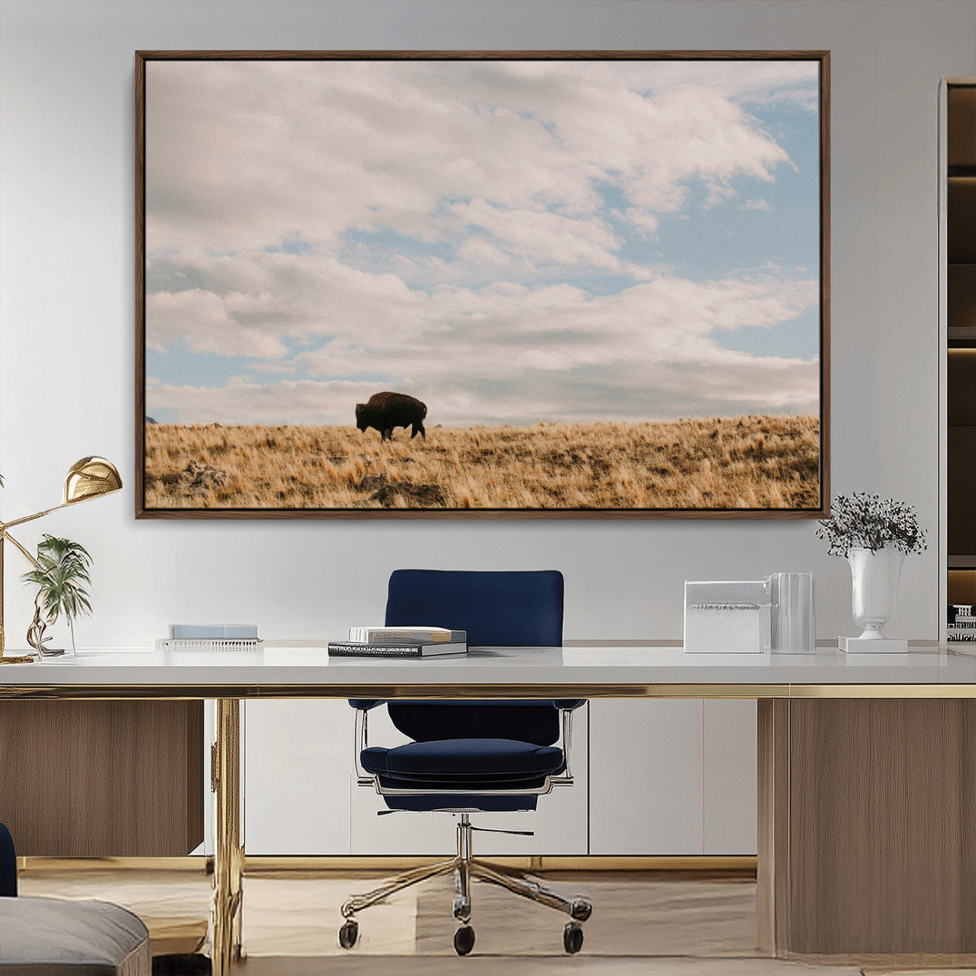 A solitary bison walking across a golden prairie under a vast, cloud-filled sky, evoking a peaceful, rustic western landscape for home decor.