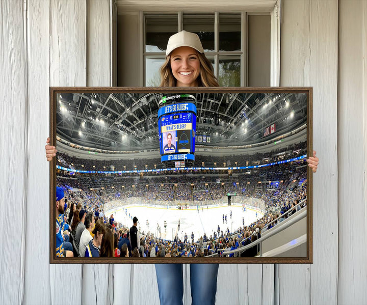 Wall art prints depicting the bustling scenes of the St. Louis Blues being cheered on by a full house at the Enterprise Center, beneath a large scoreboard.