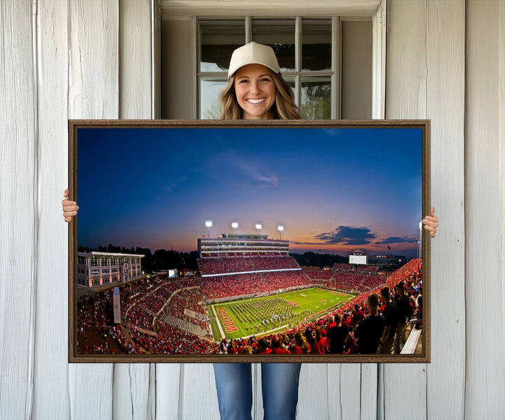 A vibrant and dynamic painting captures the essence of an electrifying night game at Carter-Finley Stadium, highlighting the illuminated atmosphere as the NC State Wolfpack competes under bright stadium lights.