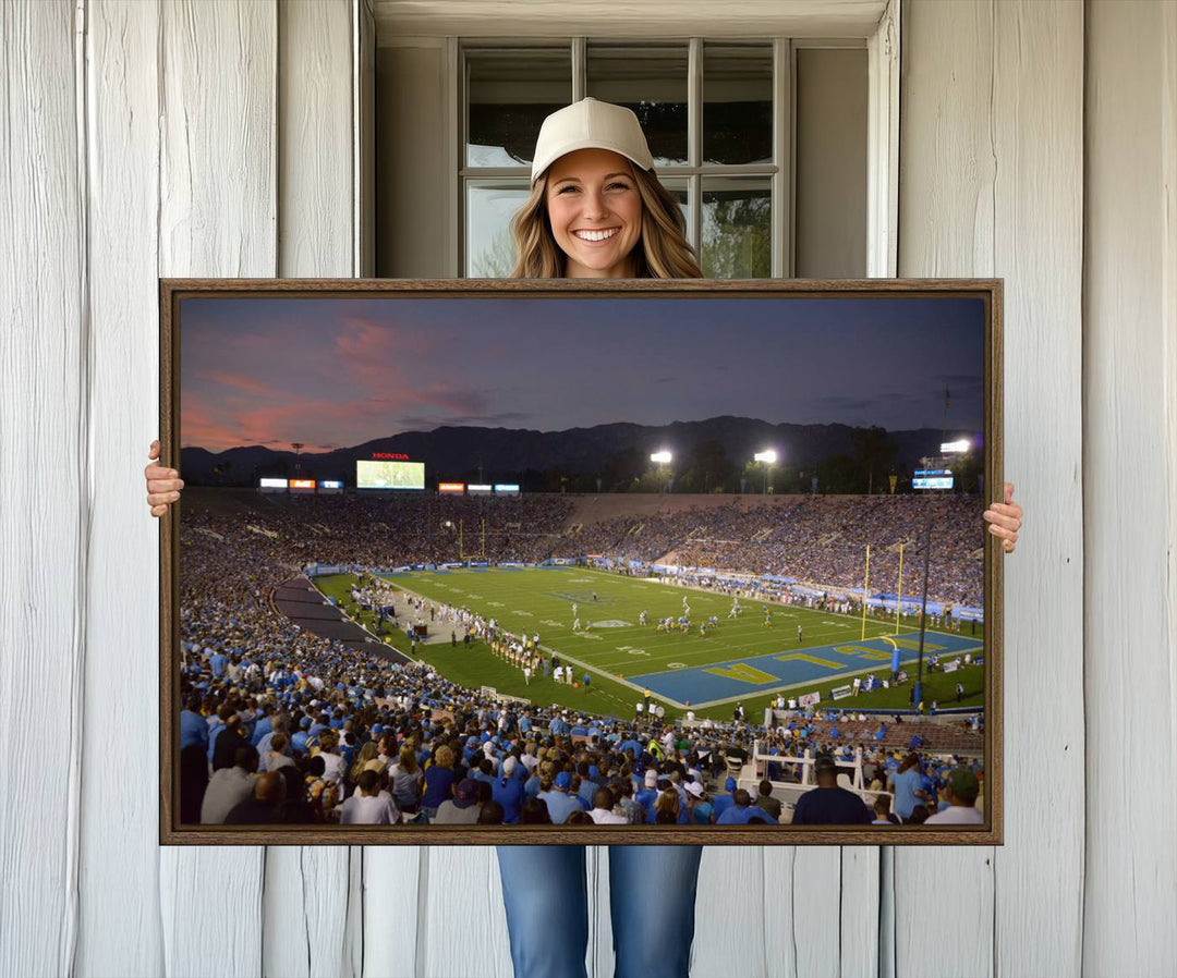 Admire the stunning wall art canvas depicting a UCLA Bruins game with a sunset over the Pasadena Rose Bowl Stadium.