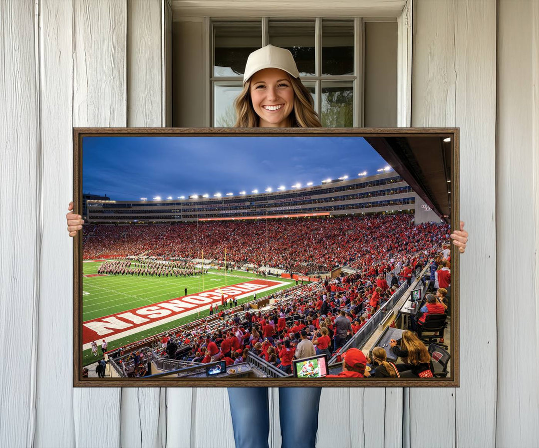 A vibrant wall art captures the essence of Madison Camp Randall Stadium, depicting a sea of fans in red and white during a Wisconsin Badgers football game under bright lights.