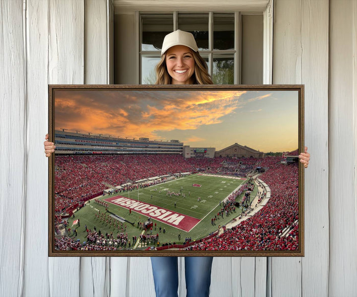 The wall features a Wisconsin Badgers wall art canvas print, capturing the vibrant atmosphere of a full Camp Randall Stadium at sunset.