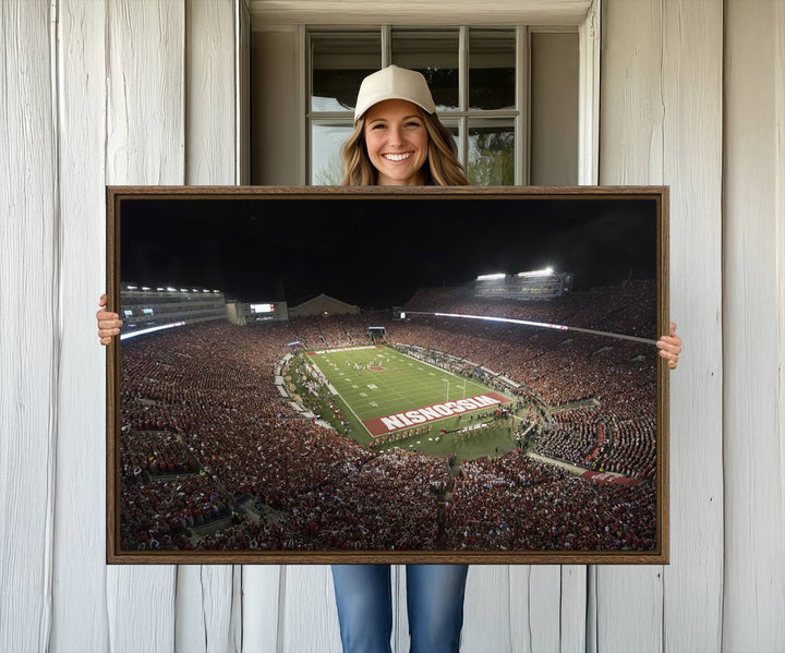 A painting of a stadium packed for a Wisconsin Badgers game, with WISCONSIN clearly visible in the end zone at Camp Randall Stadium.