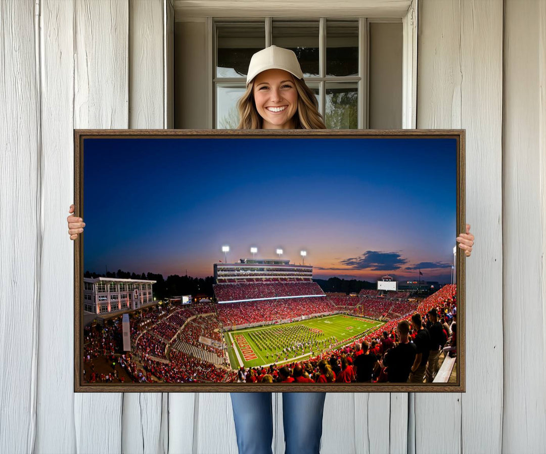 The Wolfpack Football Team Print captures a band and crowd at dusk in a premium canvas art style at Raleigh Carter-Finley Stadium.