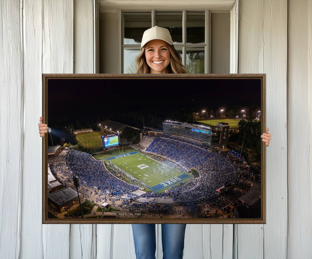 Night aerial view of packed Duke Blue Devils Wallace Wade Stadium, surrounded by trees and illuminated by lights; perfect for high-resolution prints.