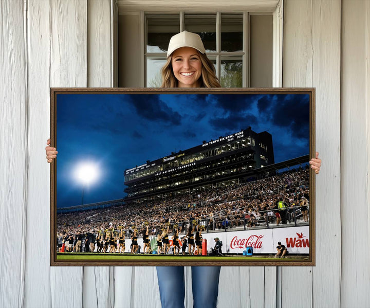 A gallery-quality canvas print depicting a stadium packed with fans under a night sky, highlighting the UCF Knights Football Team.