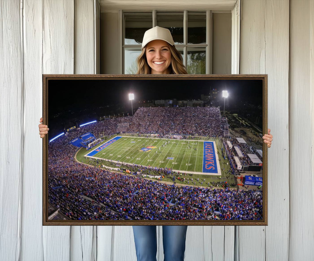 A canvas depicting an aerial view of the University of Kansas Memorial Stadium, showcasing bright lights and a lush green field at night.