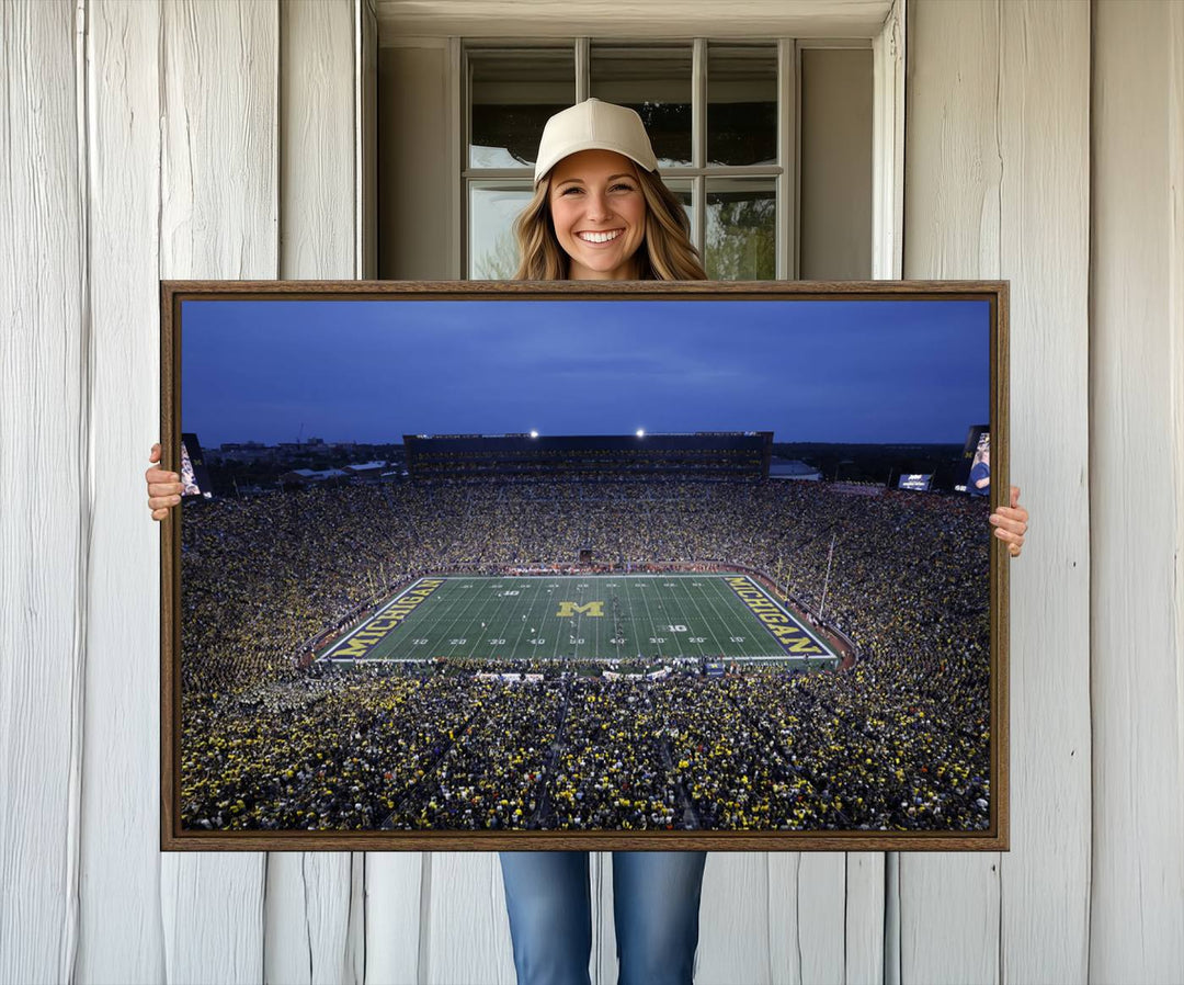 Wall art featuring an aerial shot of Michigan Stadium at dusk, showcasing the University of Michigan Wolverines M logo.