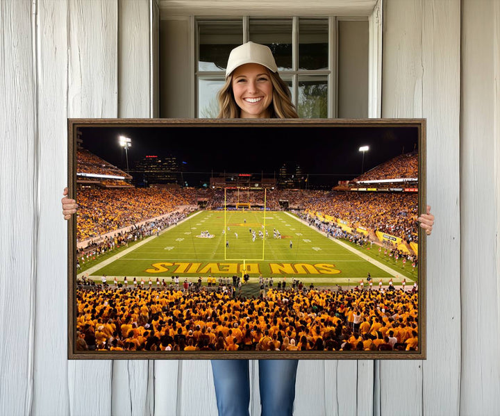 The Phoenix Stadium Canvas Wall Art features a vibrant depiction of a packed stadium filled with ASU Sun Devils fans wearing yellow shirts.