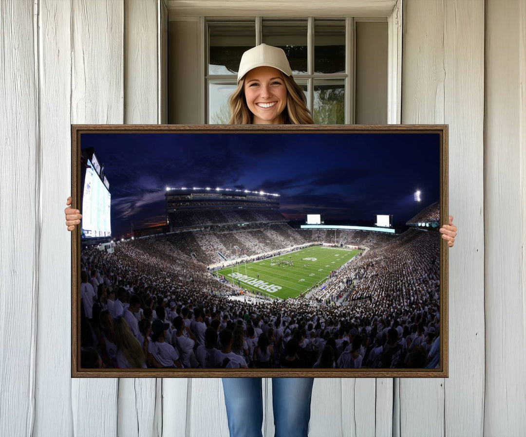 A packed football stadium at night, with bright lights and fans in white, depicted in a Michigan State Spartans Stadium wall art.