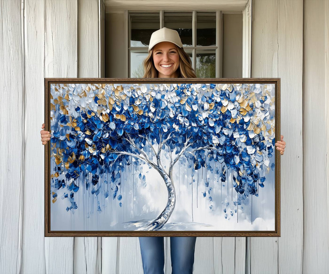 The Blue and Gold Abstract Tree Wall Art showcases a swirl trunk and features blue, silver, and gold leaves on a framed canvas print.