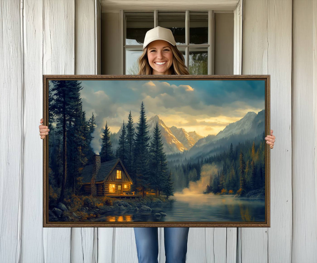 Serene sunset lake wall art: a cozy mountain cabin with lights, framed by pine trees and set against a moody sky. Ideal for adding rustic lodge charm to your space.